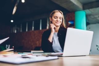 Woman smiling at laptop screen