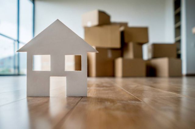 A small paper house sitting on a livingroom table