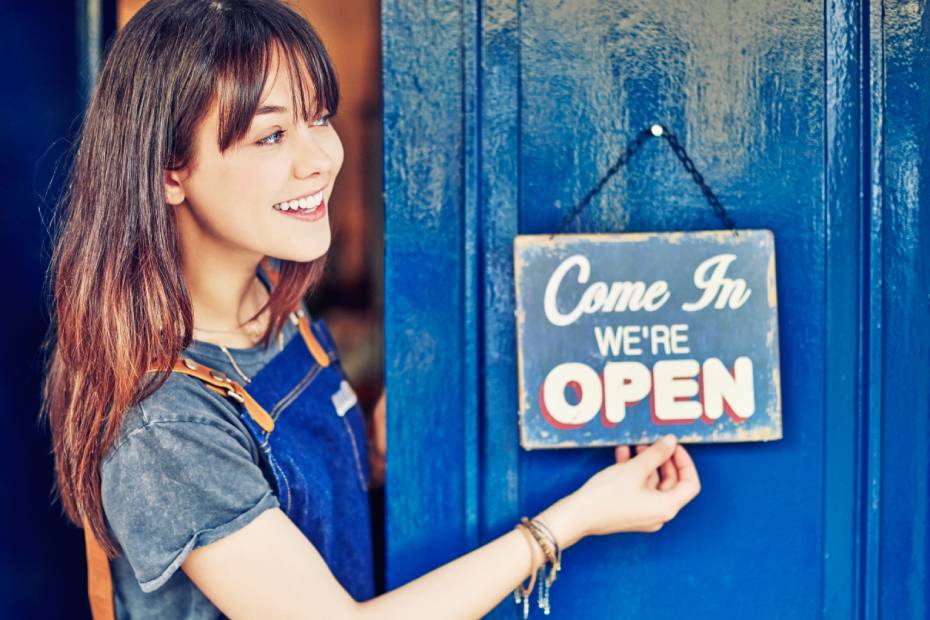 Female business owner holding open sign