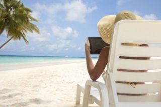 Lady on a tablet on the beach