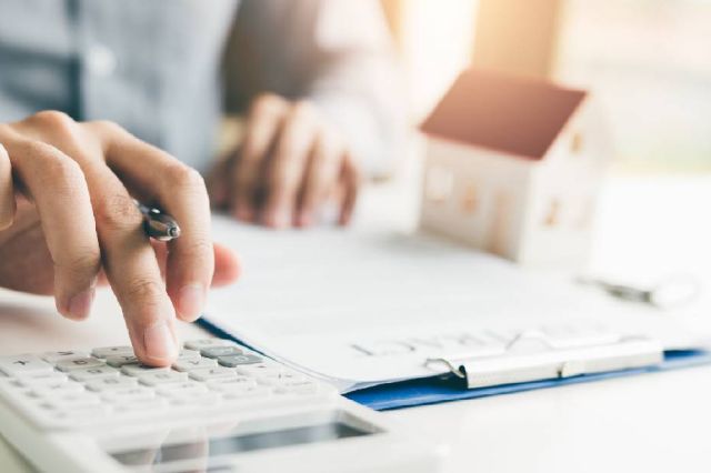 Close up image of hands working on refinancing documents