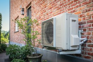 Two air-source heat pumps outside a modern energy-efficient home