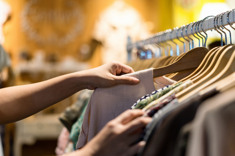 A person searches for natural linen clothing as they shop in a thrift store