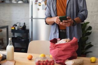 A person reviews the cost of groceries.