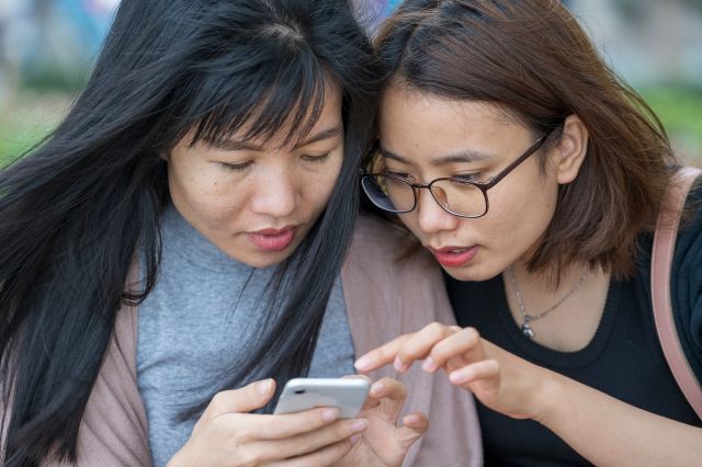 Two women looking at their mobile device