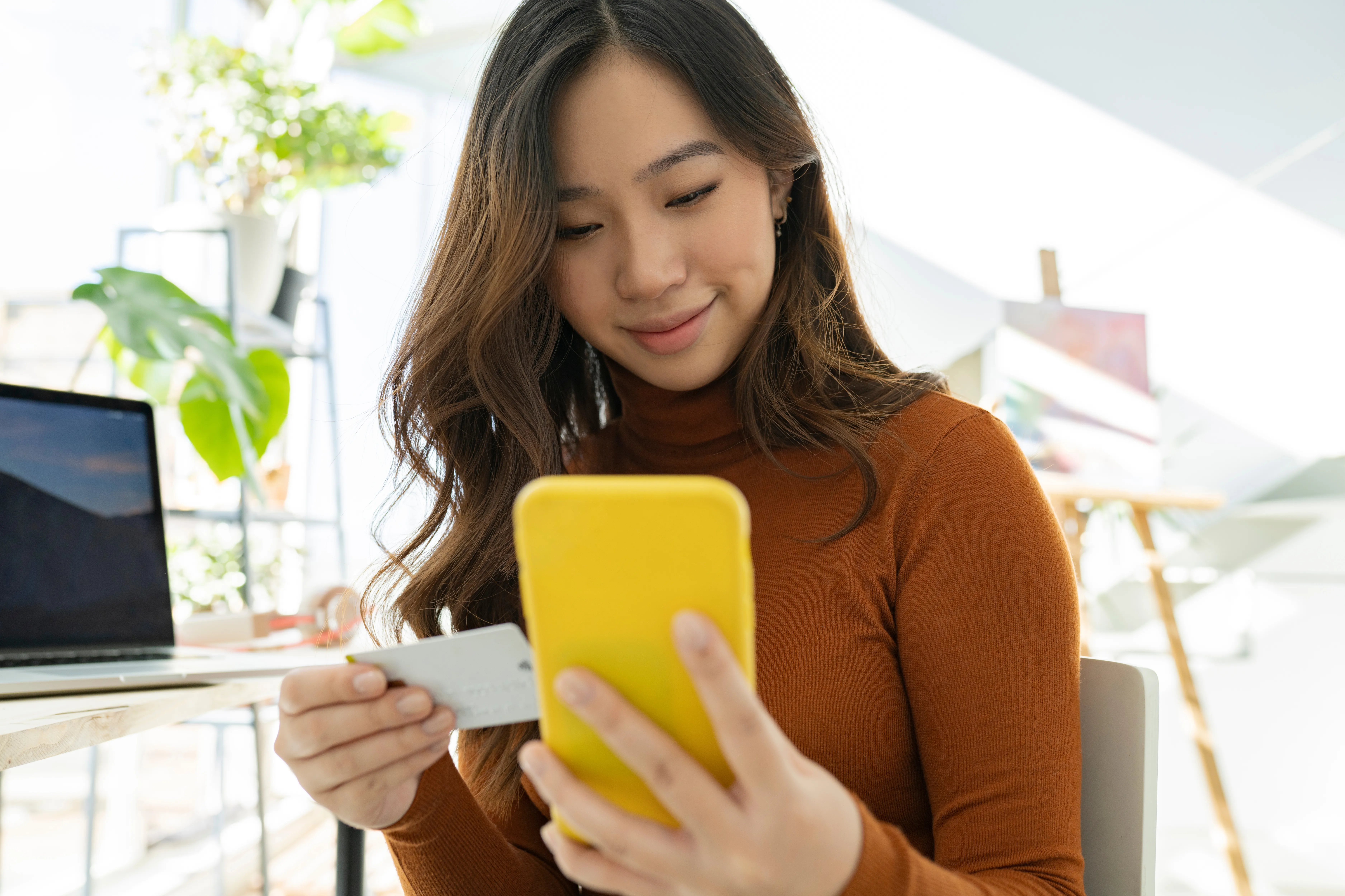 Businesswomen doing online shopping through mobile phone at home