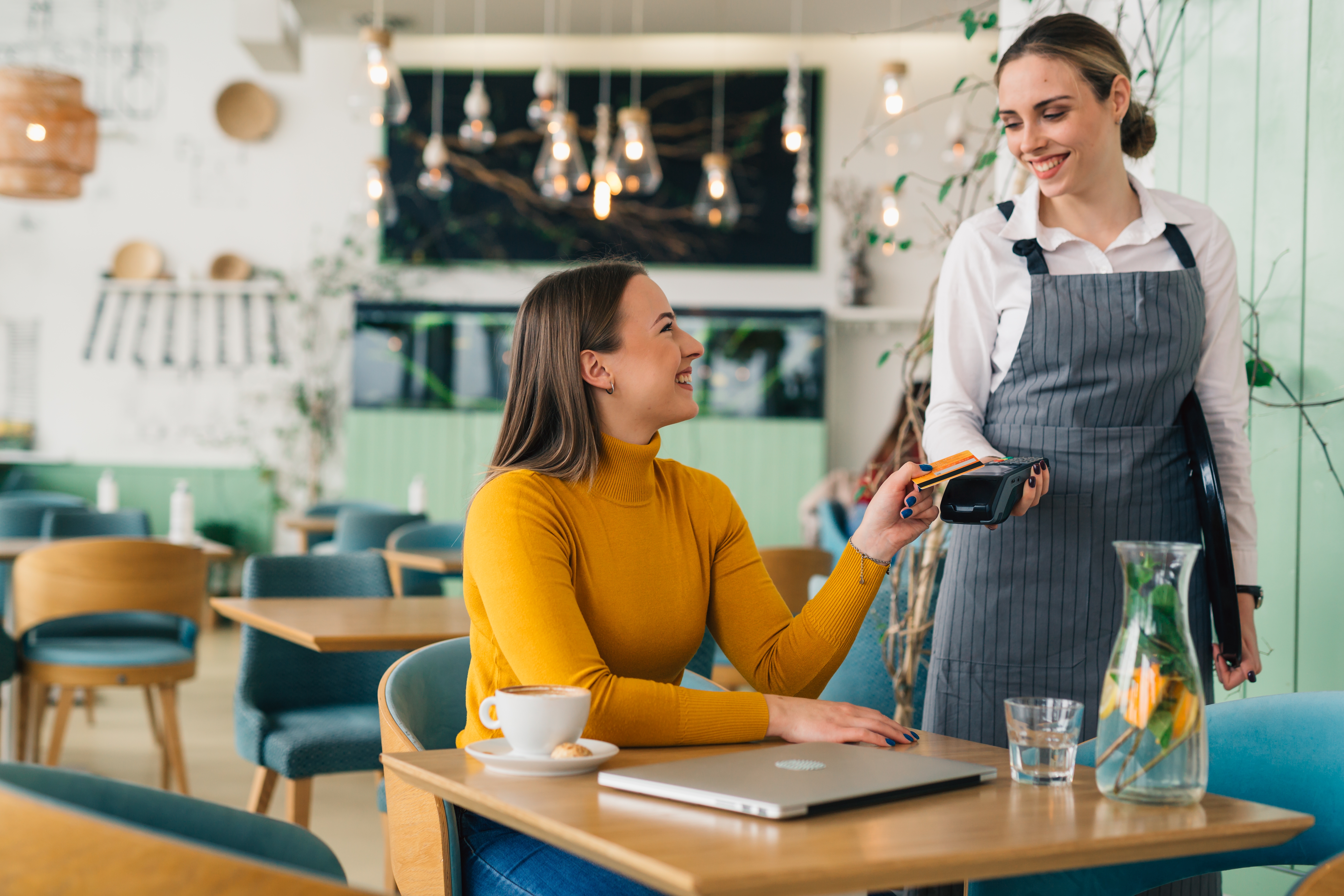 Cafe worker accepting payment from customer