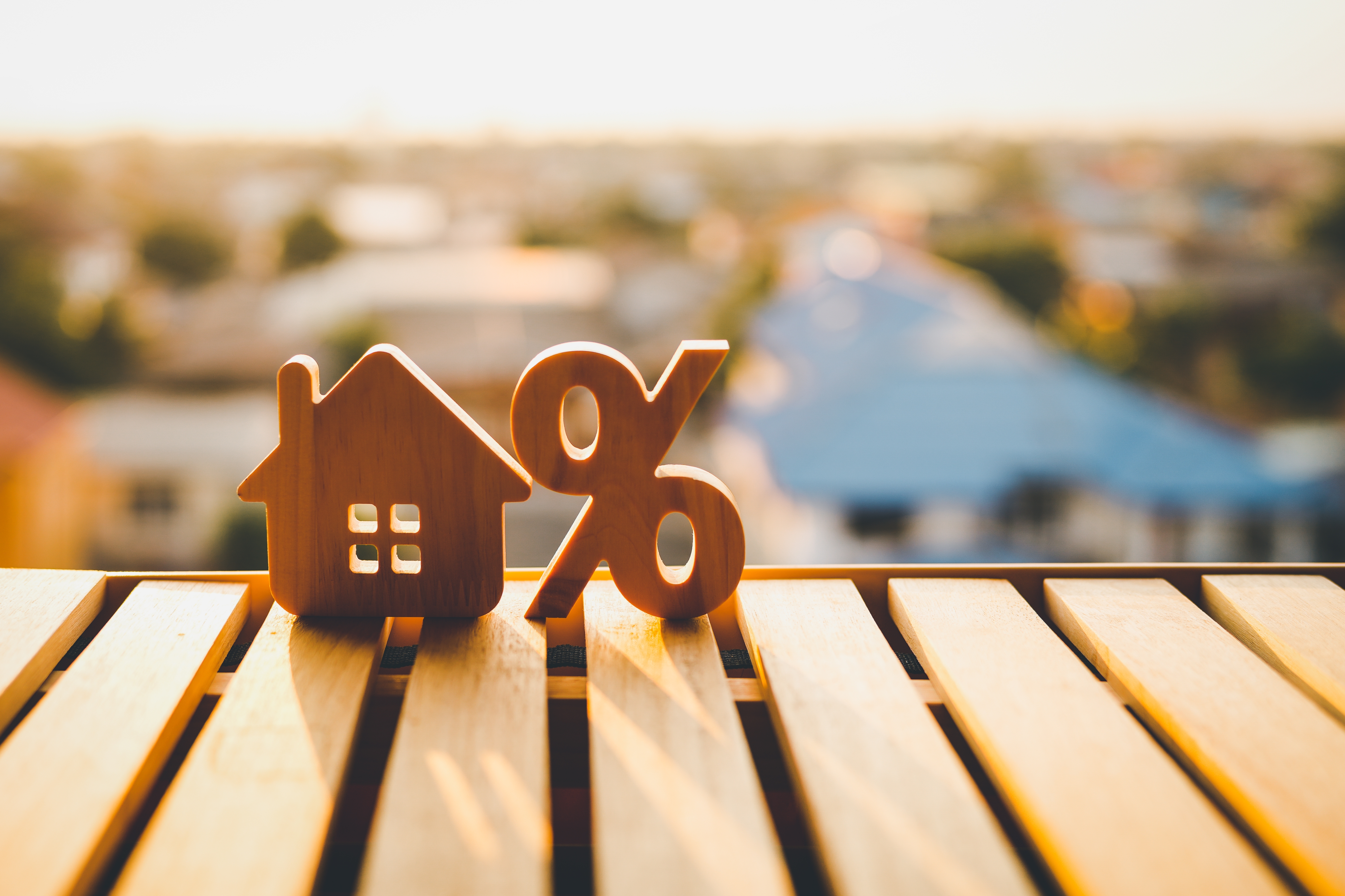 Percentage and wooden house icon on the wood table