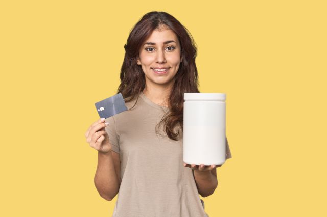 Young women with credit card and protein bottle