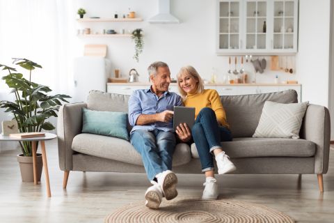 Cheerful spouses using digital tablet together