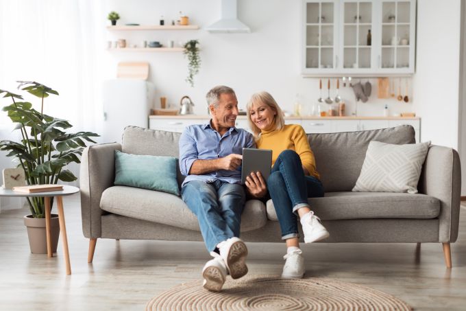 Cheerful spouses using digital tablet together