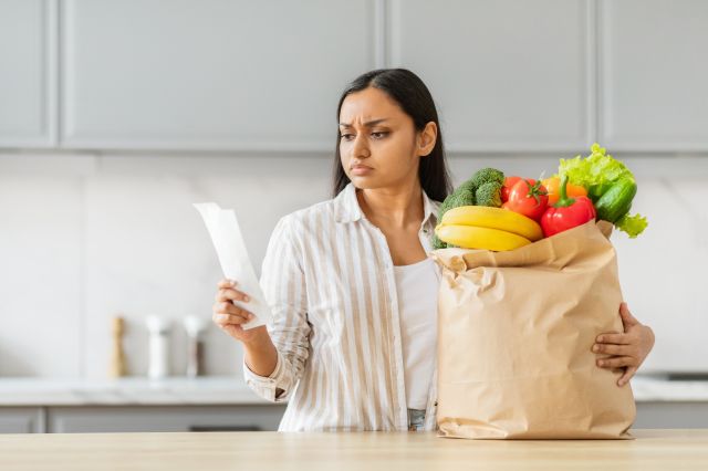 A woman reviewing the grocery receipt bill