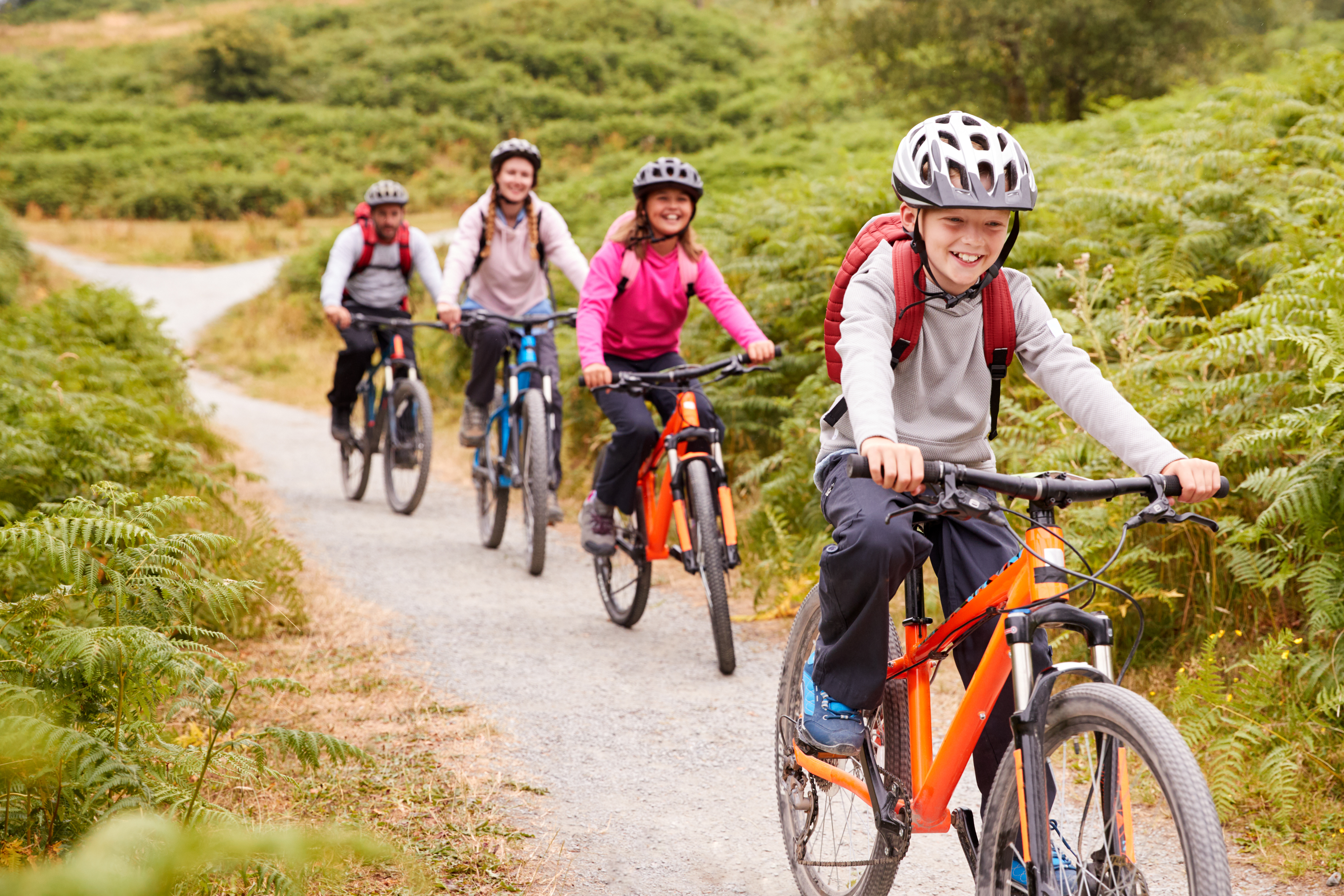 Boy riding mountain bike with family