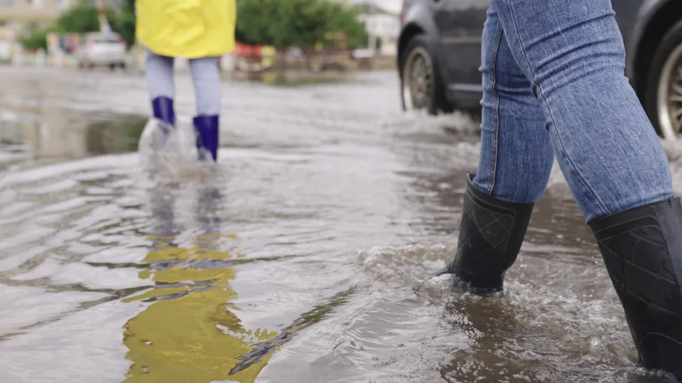 Girl in raincoat and rubber boats