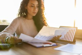 Une femme assise à un bureau regarde un écran d'ordinateur