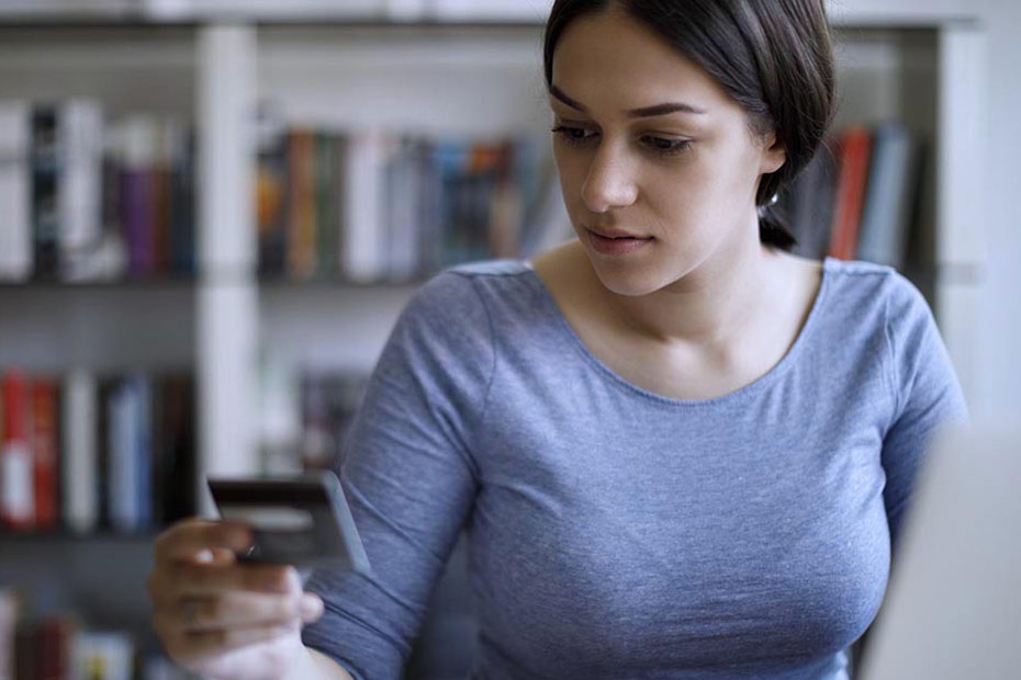 Image montrant une jeune femme payant des factures avec une carte de crédit