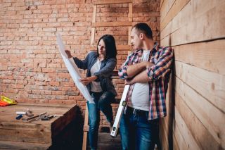 Un couple heureux prend part à la conception de rénovations domiciliaires.