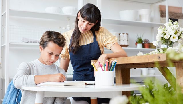 Mère aidant son fils à faire ses devoirs à une table de cuisine.