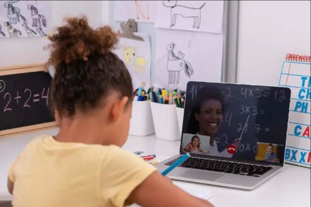 Jeune fille à son bureau durant un appel Zoom pour l’école