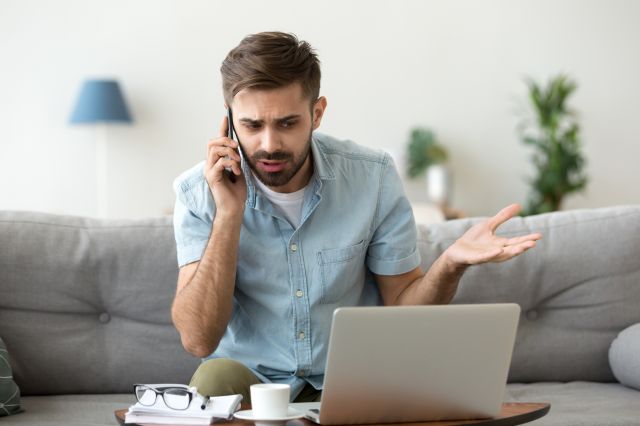 Un homme en colère parlant au téléphone contestant un problème d'ordinateur portable, stressé, un client impatient et insatisfait se disputant par mobile, résolvant des difficultés en ligne avec le support technique, se plaignant d'un mauvais service