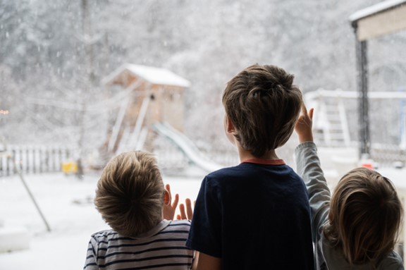 Trois enfants regardant par la fenêtre