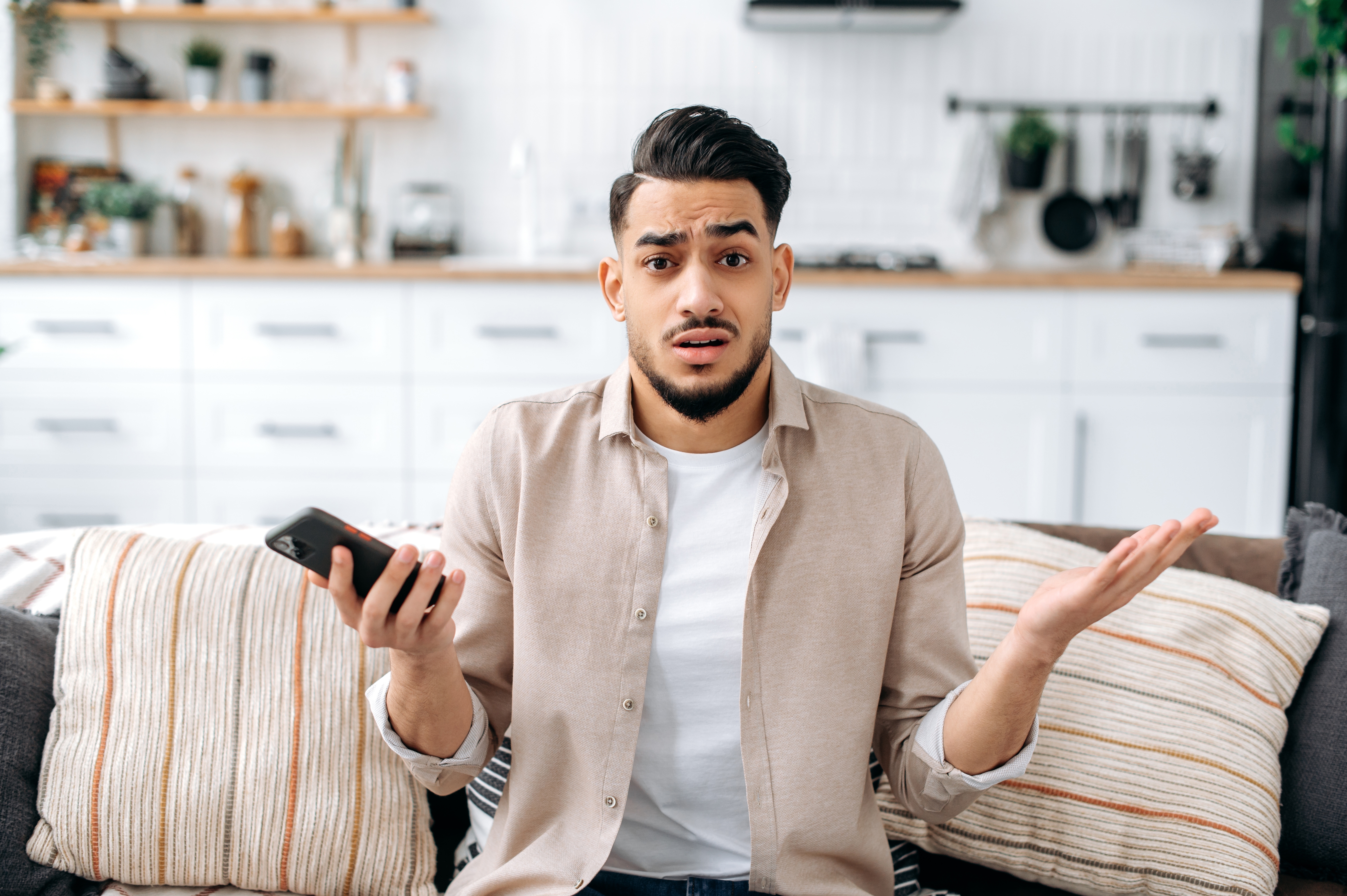 Homme confus avec le téléphone à la main