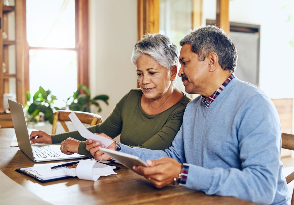 Couples de personnes âgées planifiant un budget avec un ordinateur