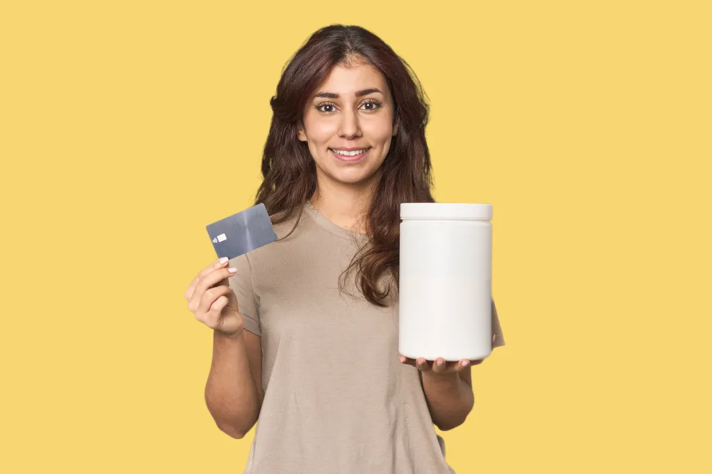 Jeunes femmes avec carte de crédit et bouteille de protéines