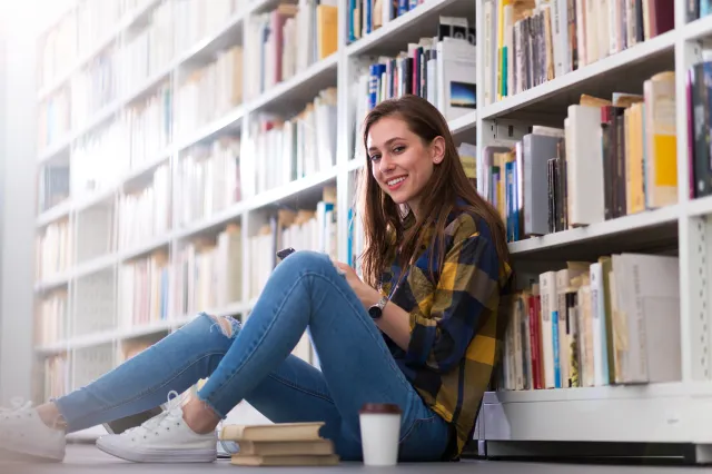 Jeune étudiante étudiant à la bibliothèque