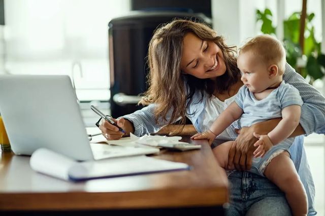 Une femme et son bébé sur un ordinateur portable