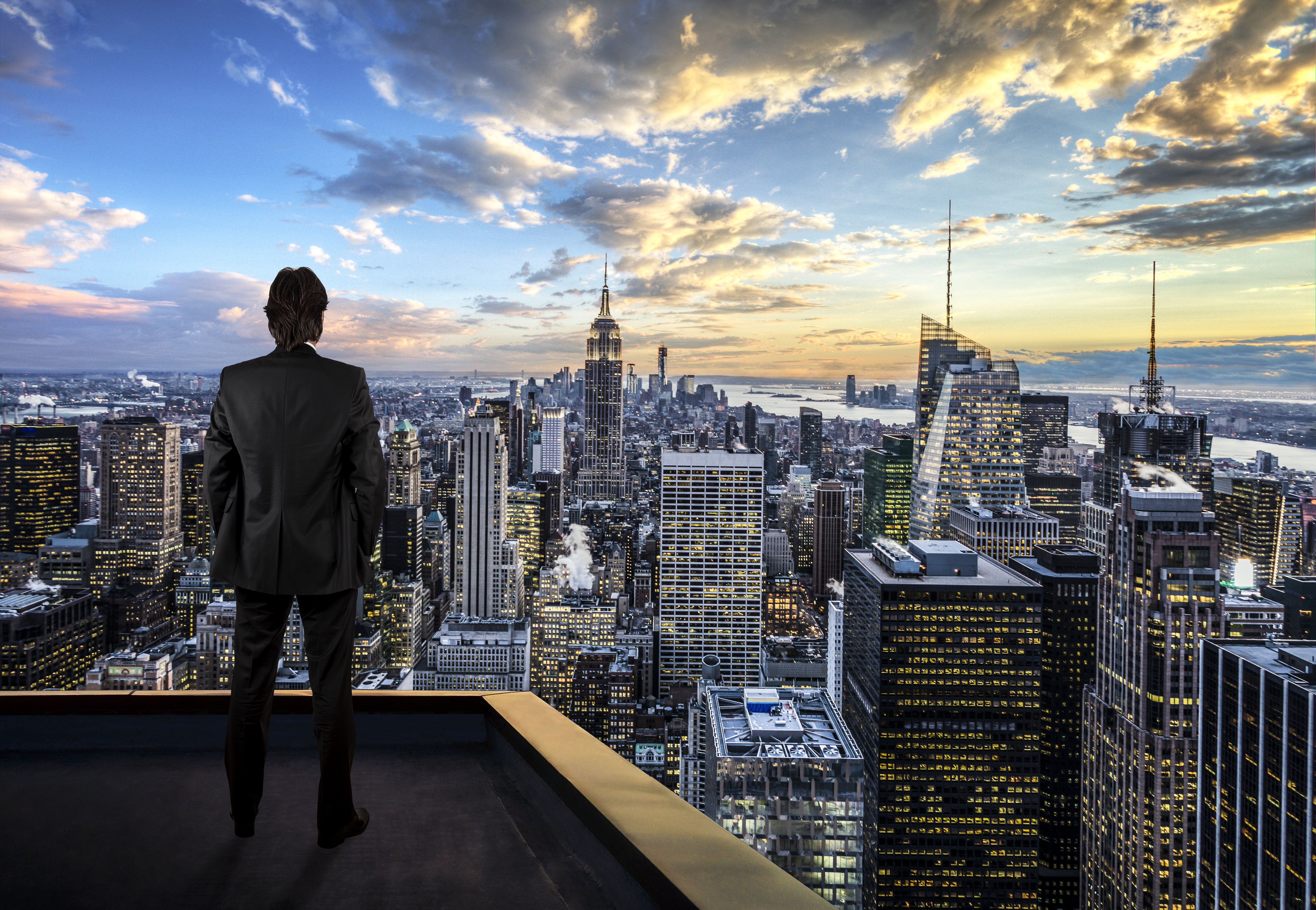 Homme d'affaires regardant la ville de New York sur le toit d'un gratte-ciel