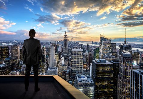 Homme d'affaires regardant la ville de New York sur le toit d'un gratte-ciel