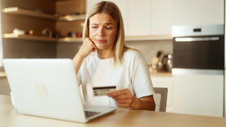 Femmes confuses avec une carte de crédit regardant l'écran