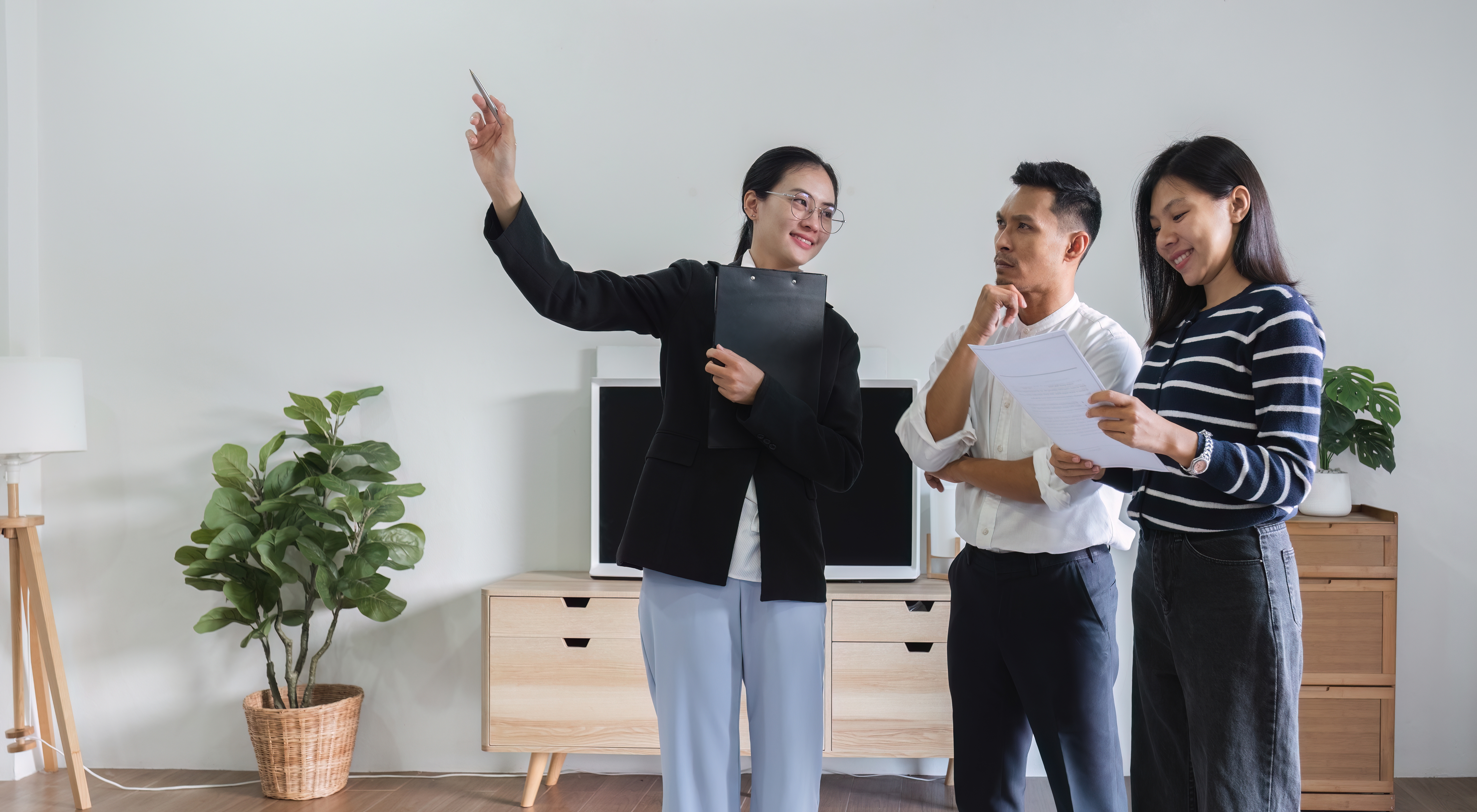 Un couple d’immigrants pose des questions à un courtier immobilier avant de louer leur premier logement au Canada